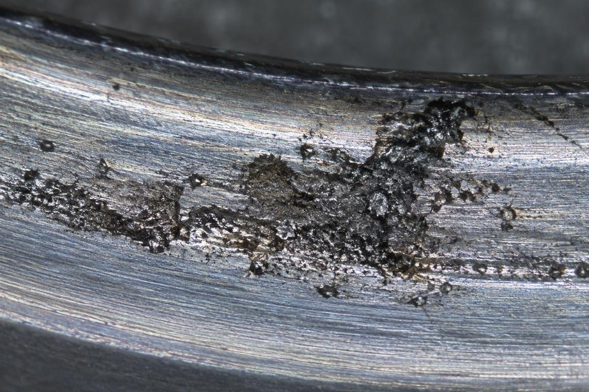 Microscopic view of contamination damage in bearing raceway